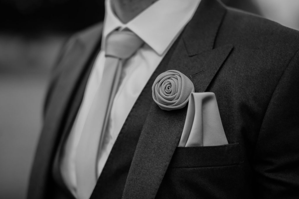 greyscale photo of man wearing peak lapel suit jacket